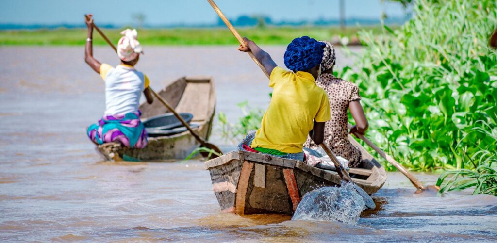 Vrouwen varen in een kano in Benin, Afrika