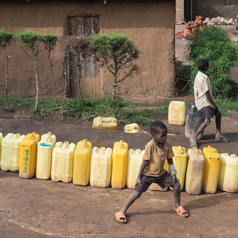 Mensen in DR Congo schuiven aan voor een bidon drinkwater.