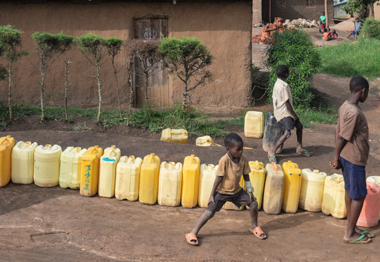 Mensen in DR Congo schuiven aan voor een bidon drinkwater.